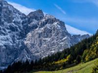 Steile Karwendelwand über beleuchtetem Bergwald